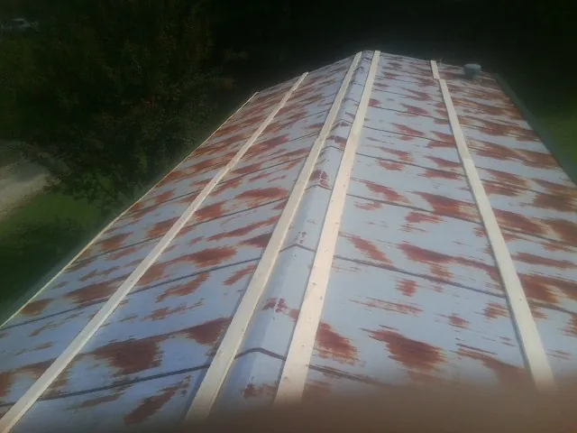 Rusted metal roof panels with new wood purlins before replacement — Storm Damage Roof Repair in Faucett by Roofing Brothers